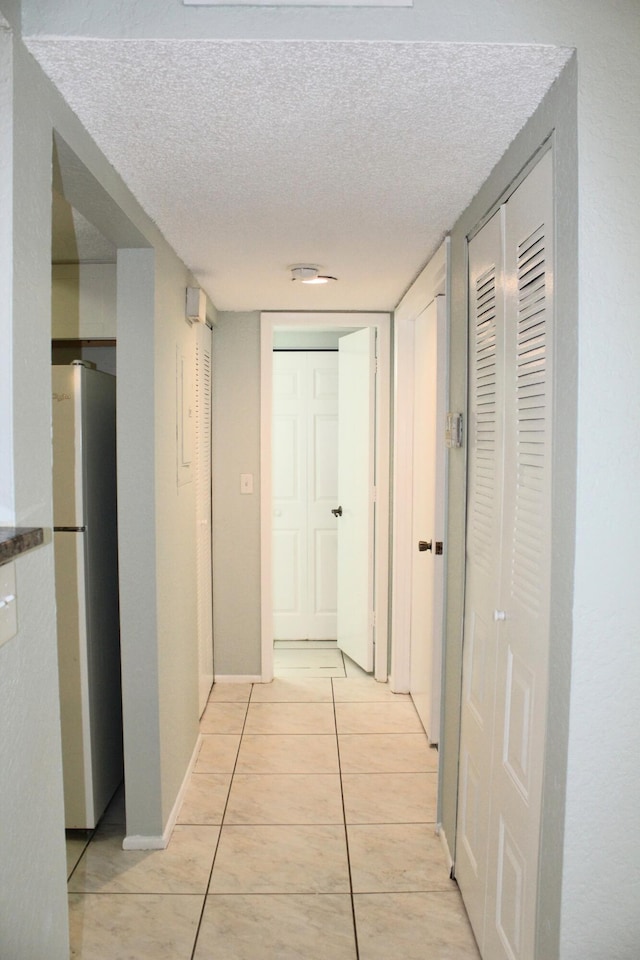 1500 SE Royal Green Cir Unit 208, Port Saint Lucie, FL 34952 - hall featuring a textured ceiling, light tile patterned floors, and baseboards
