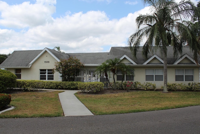 1500 SE Royal Green Cir Unit 208, Port Saint Lucie, FL 34952 - view of front of property featuring a front lawn, stucco siding, and a shingled roof