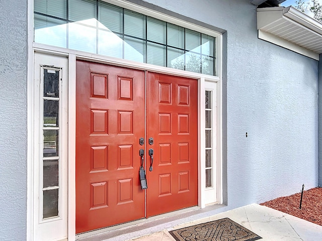 entrance to property featuring stucco siding