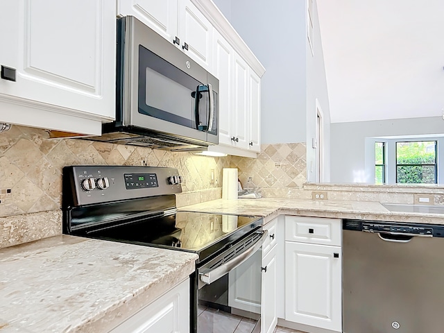 kitchen with appliances with stainless steel finishes, white cabinetry, light countertops, a sink, and decorative backsplash