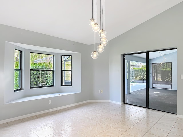 spare room featuring baseboards and vaulted ceiling