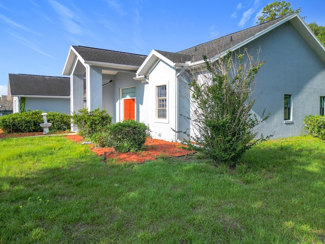 view of front of property with stucco siding and a front lawn