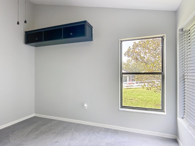 carpeted spare room featuring baseboards