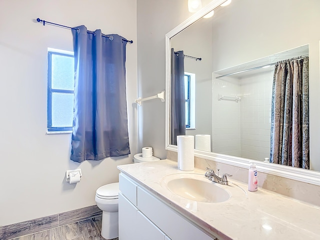 bathroom featuring toilet, vanity, a shower with shower curtain, and wood finished floors