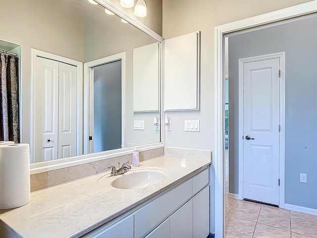 full bathroom featuring vanity, tile patterned flooring, and baseboards