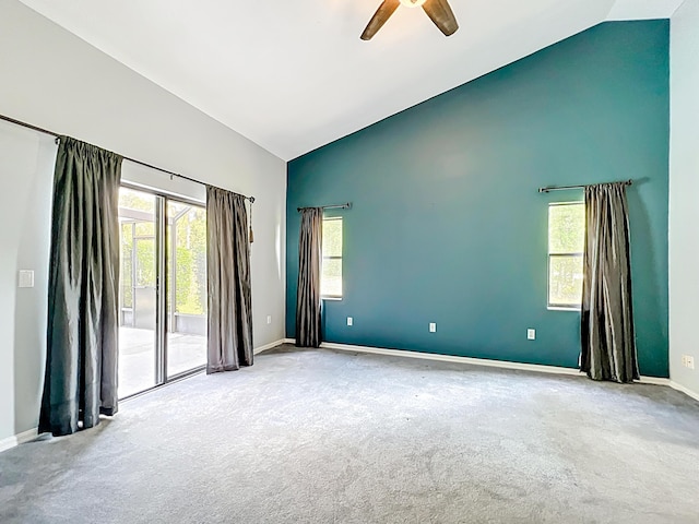 carpeted spare room featuring baseboards, a ceiling fan, and high vaulted ceiling