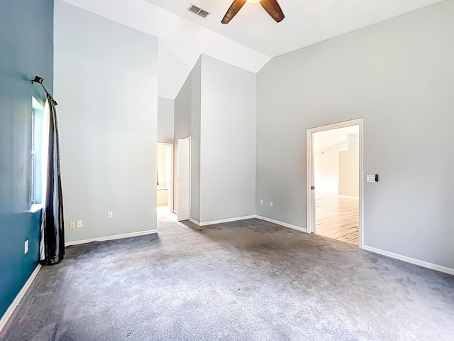 carpeted spare room with high vaulted ceiling, a ceiling fan, and baseboards