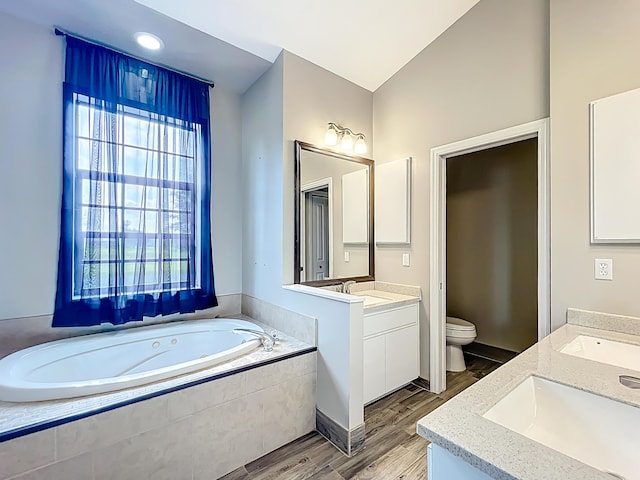 full bathroom with toilet, wood finished floors, vanity, and a bath