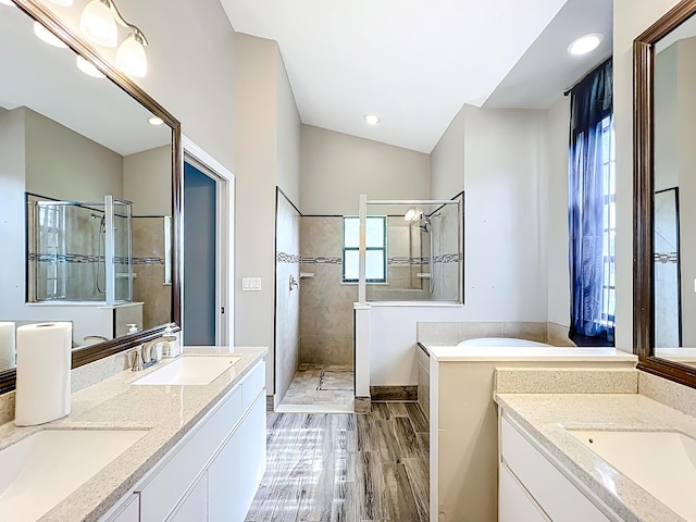 bathroom featuring walk in shower, wood finished floors, double vanity, and recessed lighting