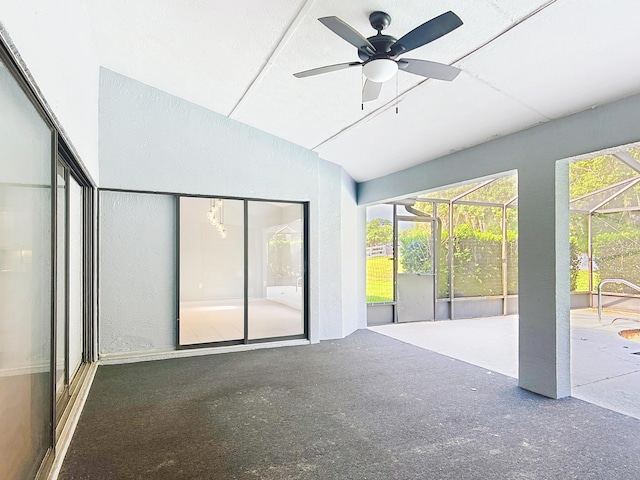 unfurnished sunroom with ceiling fan and vaulted ceiling