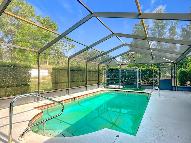 view of swimming pool featuring a patio area, a fenced backyard, and glass enclosure