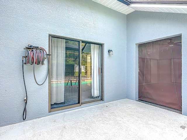 doorway to property featuring stucco siding