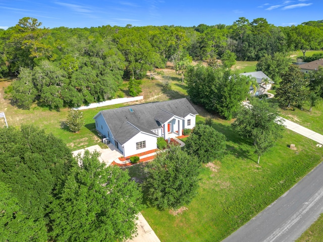 aerial view of property and surrounding area featuring a heavily wooded area