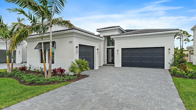 13250 Artisan Cir, Palm Beach Gardens, FL 33418 - view of front facade featuring a garage, stucco siding, and decorative driveway
