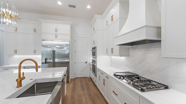 13250 Artisan Cir, Palm Beach Gardens, FL 33418 - kitchen featuring premium range hood, stainless steel appliances, white cabinets, decorative backsplash, and recessed lighting