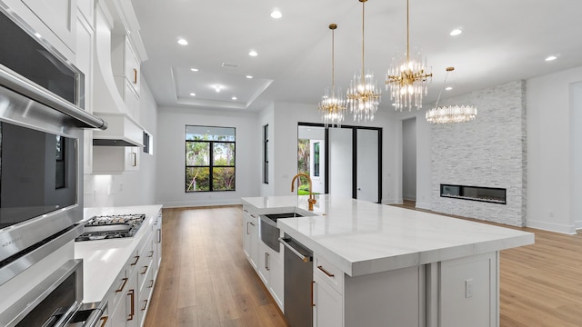13250 Artisan Cir, Palm Beach Gardens, FL 33418 - kitchen with open floor plan, appliances with stainless steel finishes, a chandelier, light wood-style flooring, and recessed lighting