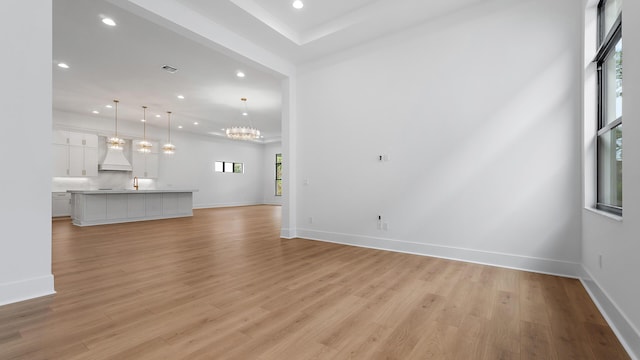 13250 Artisan Cir, Palm Beach Gardens, FL 33418 - unfurnished living room with recessed lighting, light wood-style floors, and a chandelier