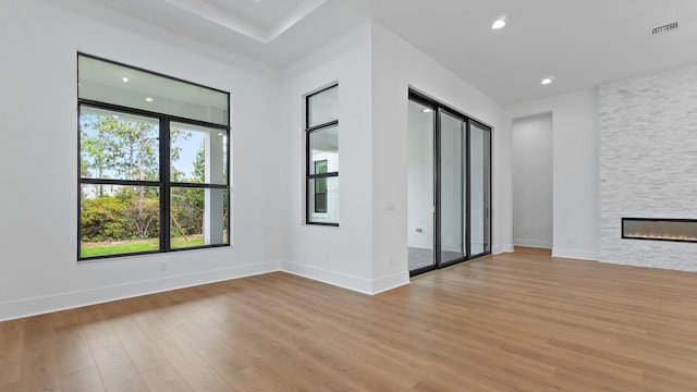 13250 Artisan Cir, Palm Beach Gardens, FL 33418 - unfurnished living room featuring light wood finished floors, a stone fireplace, and recessed lighting