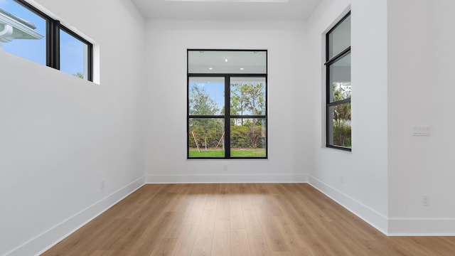 13250 Artisan Cir, Palm Beach Gardens, FL 33418 - empty room with healthy amount of natural light and light wood-style floors