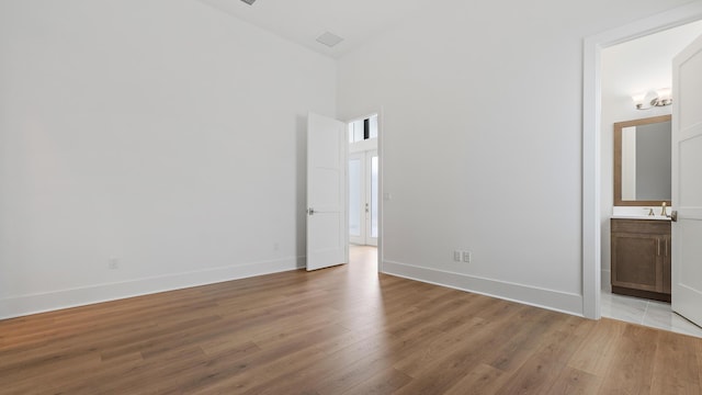 13250 Artisan Cir, Palm Beach Gardens, FL 33418 - empty room featuring light wood-style floors and a high ceiling