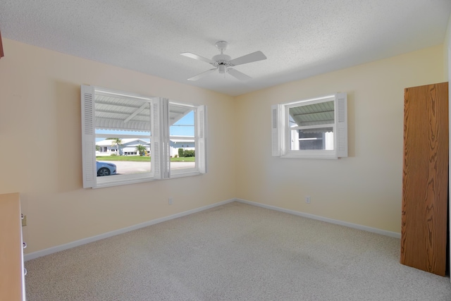 unfurnished bedroom with multiple windows, carpet flooring, baseboards, and a textured ceiling
