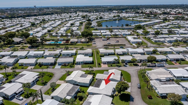 aerial view of property and surrounding area featuring nearby suburban area and a large body of water