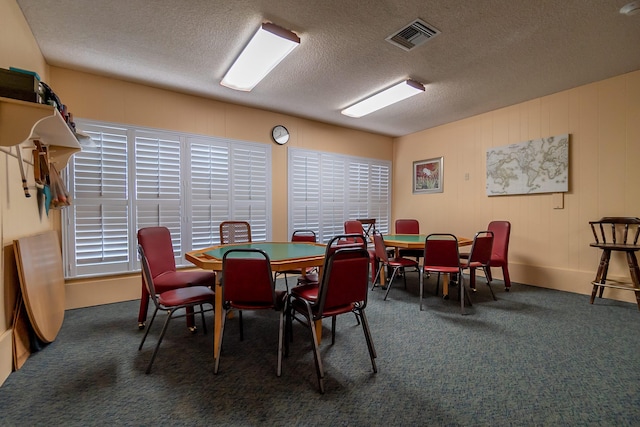 dining room featuring carpet flooring and a textured ceiling