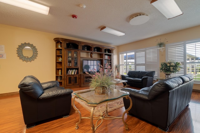 living area with a textured ceiling and wood finished floors
