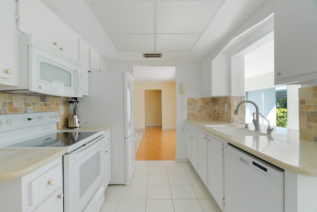 631 SW 21st Cir, Boynton Beach, FL 33426 - kitchen with white appliances, a sink, backsplash, light countertops, and white cabinets