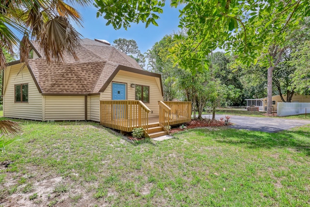 1130 Melinda Ln, Haverhill, FL 33417 - back of house with a shingled roof, a wooden deck, and a yard
