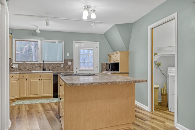 1130 Melinda Ln, Haverhill, FL 33417 - kitchen featuring a sink, light brown cabinets, black appliances, light wood-style flooring, and washer / clothes dryer