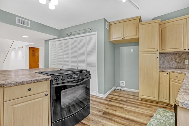 1130 Melinda Ln, Haverhill, FL 33417 - kitchen with black electric range oven, light brown cabinets, light countertops, light wood-type flooring, and baseboards