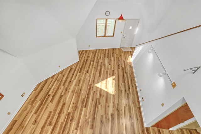 1130 Melinda Ln, Haverhill, FL 33417 - unfurnished living room featuring light wood finished floors, baseboards, and lofted ceiling