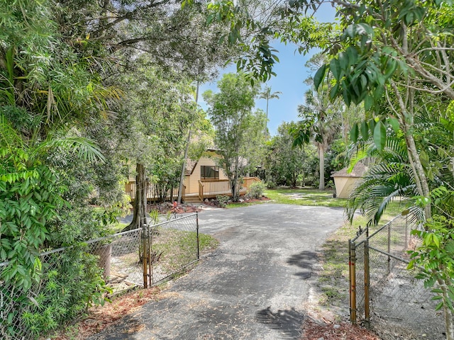 1130 Melinda Ln, Haverhill, FL 33417 - view of asphalt driveway featuring a gated entry