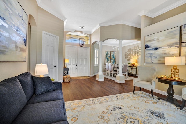 11354 Mainsail Ct, Wellington, FL 33449 - living room featuring ornate columns, arched walkways, wood finished floors, ornamental molding, and baseboards
