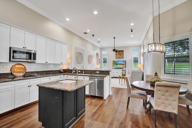 11354 Mainsail Ct, Wellington, FL 33449 - kitchen with appliances with stainless steel finishes, a sink, a peninsula, crown molding, and white cabinetry