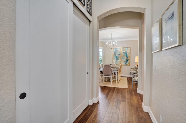 11354 Mainsail Ct, Wellington, FL 33449 - hall with crown molding, arched walkways, a chandelier, dark wood-type flooring, and baseboards