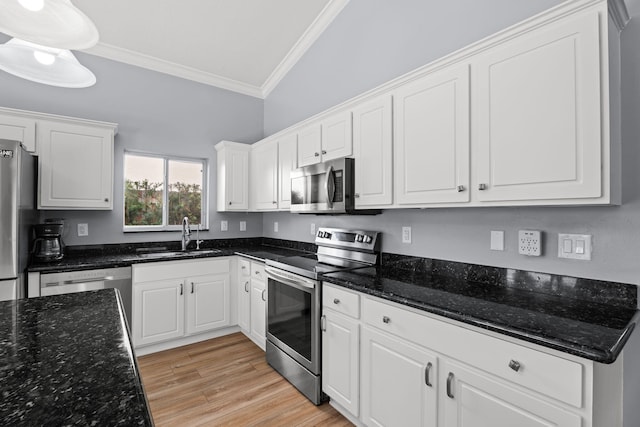4620 SE Winter Haven Ct, Stuart, FL 34997 - kitchen featuring appliances with stainless steel finishes, a sink, crown molding, white cabinets, and light wood finished floors