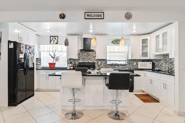 645 Monaco N, Delray Beach, FL 33446 - kitchen with black appliances, wall chimney exhaust hood, a sink, and dark countertops