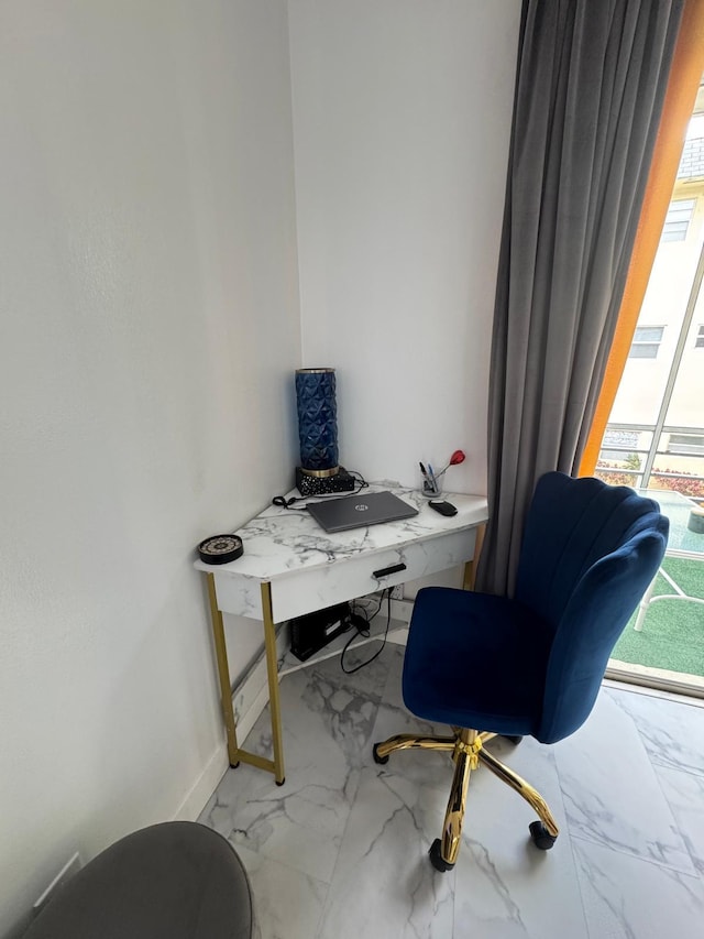 home office featuring marble look tiles, plenty of natural light, and baseboards