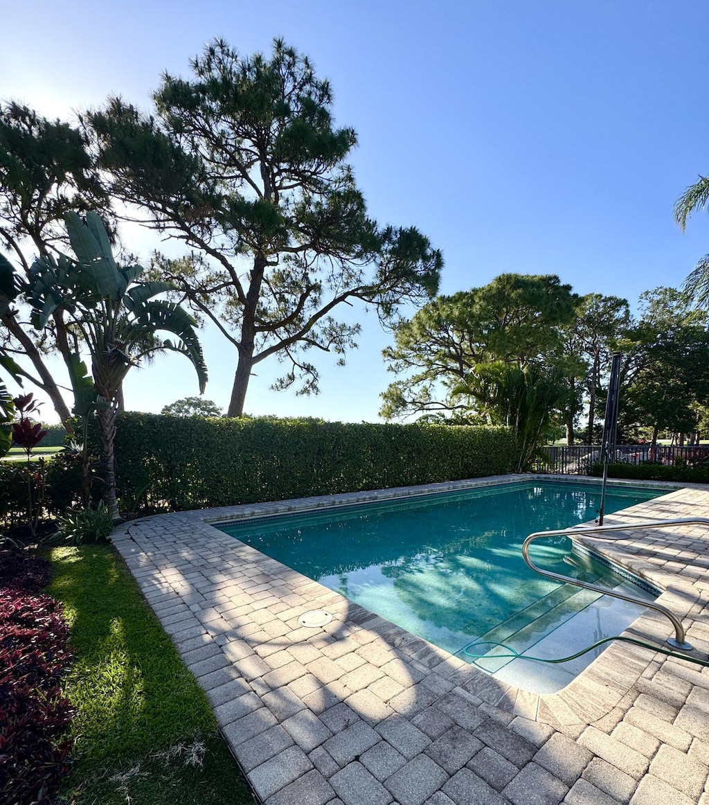 view of swimming pool featuring fence and a patio