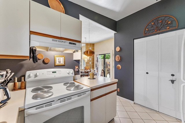 11 Meadows Dr, Boynton Beach, FL 33436 - kitchen featuring electric range, under cabinet range hood, light tile patterned flooring, light countertops, and white cabinetry