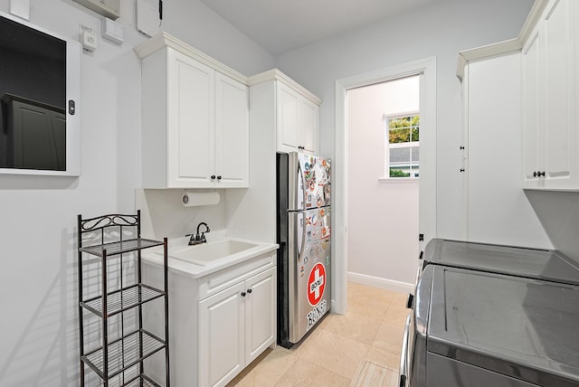 17736 103rd Ter N, Jupiter, FL 33478 - kitchen featuring freestanding refrigerator, washer and dryer, white cabinetry, and light countertops