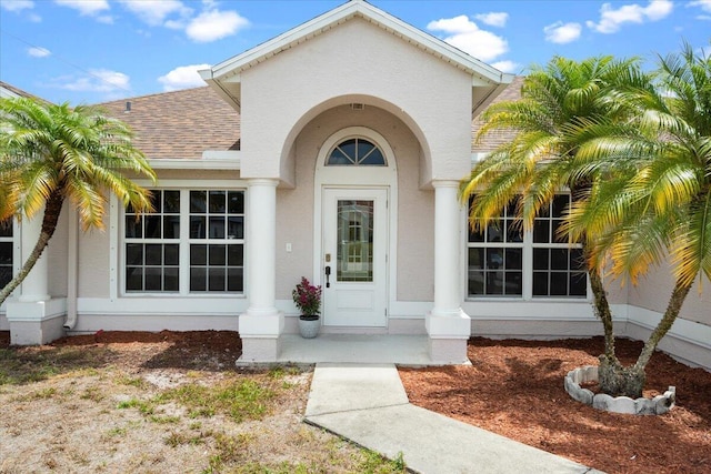 3925 SW Helmlinger St, Port Saint Lucie, FL 34953 - property entrance with a shingled roof and stucco siding