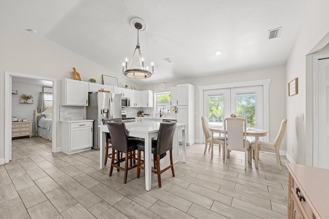 6905 Bayard Rd, Fort Pierce, FL 34951 - dining room with a chandelier, vaulted ceiling, and baseboards