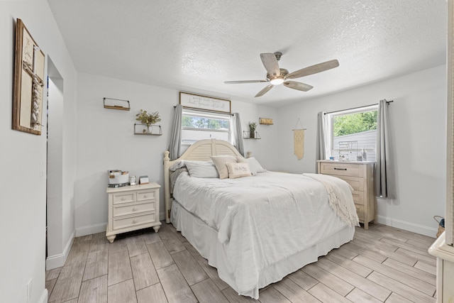 6905 Bayard Rd, Fort Pierce, FL 34951 - bedroom with wood finish floors, multiple windows, a textured ceiling, and baseboards
