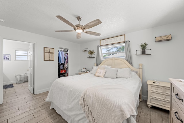 6905 Bayard Rd, Fort Pierce, FL 34951 - bedroom with multiple windows, light wood-style flooring, a walk in closet, a closet, and a textured ceiling