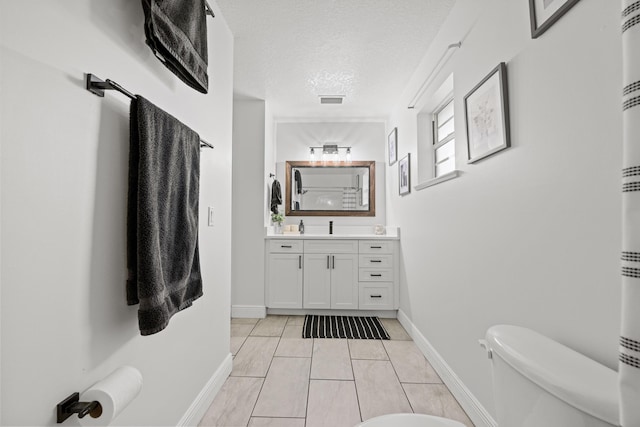 6905 Bayard Rd, Fort Pierce, FL 34951 - full bathroom with vanity, a textured ceiling, toilet, baseboards, and tile patterned floors