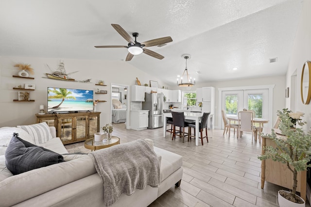 6905 Bayard Rd, Fort Pierce, FL 34951 - living room with a ceiling fan, vaulted ceiling, wood tiled floors, and a chandelier