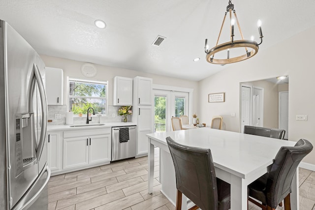 6905 Bayard Rd, Fort Pierce, FL 34951 - kitchen with stainless steel appliances, a sink, a kitchen breakfast bar, a chandelier, and light countertops
